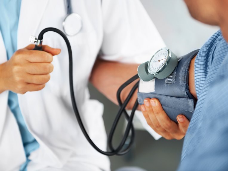 Ein Arzt misst bei einem Patienten den Blutdruck.
